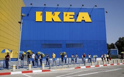 Customers try maintain a safe distance from each other as they wait in line to enter an IKEA outlet in the Israeli coastal town of Netanya on April 22, 2020, after authorities eased down some of the measures that have been in place during the novel conronavirus pandemic crisis. (Photo by JACK GUEZ / AFP)