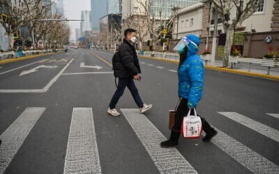 A woman wearing a face shield and mask amid the COVID-19 pandemic walks on a street in the Jing'an district in Shanghai, China, on January 9, 2023. (Hector Retamal/AFP)