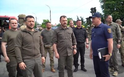 Ukrainian President Volodymyr Zelensky (front left) tours a flooding area after the collapse of the Kakhovka dam and hydroelectric plant, in Kherson, Ukraine, July 8, 2023. (Twitter video screenshot: Used in accordance with Clause 27a of the Copyright Law)