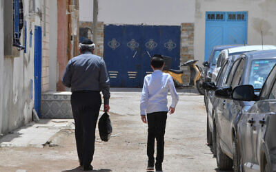A Jewish man and a child walk through the Hara Kebira, the main Jewish quarter on the island of Djerba, near the Ghriba synagogue following a shooting attack on May 10, 2023 (FETHI BELAID / AFP)