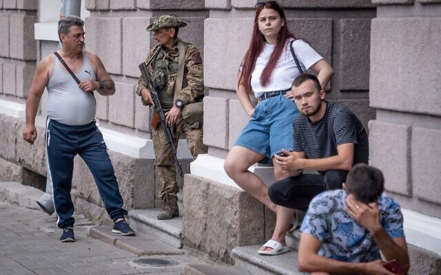 A member of Wagner group speaks with a local resident in Rostov-on-Don, on June 24, 2023. (Roman Romokohv / AFP)