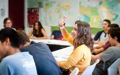 A student raises her hand in class. (Courtesy Alexander Muss High School in Israel via JTA)