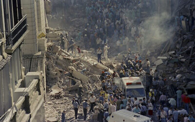 In this March 17, 1992, file photo, firemen and rescue workers walk through the debris of Israel's Embassy after a terrorist in Buenos Aires, Argentina. (AP Photo/DonRypka-File )