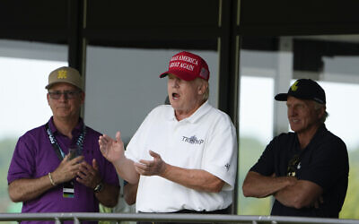 Former US President Donald Trump, Greg Norman, LIV Golf CEO, right, and Paul Myler, deputy head of mission for the Australian Embassy in Washington, left, watch the second round of the LIV Golf at Trump National Golf Club, Saturday, May 27, 2023, in Sterling, Va. (AP/Alex Brandon)