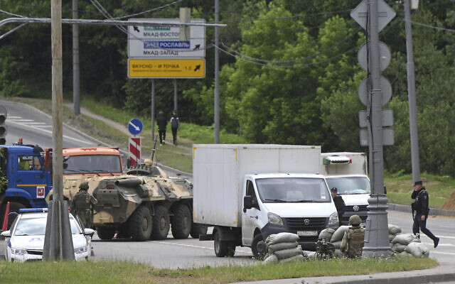 Russian army servicemen and police officers guard the highway at the entrance to Moscow, June 24, 2023. (AP Photo)
