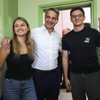 Kyriakos Mitsotakis, center, leader of center-right New Democracy party poses for the media with his daughter Dafni Mitsotakis, left, and son Konstantinos Mitsotakis at a polling station in Athens, Greece, June 25, 2023. (AP/ Yorgos Karahalis)