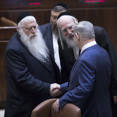Prime Minister Benjamin Netanyahu, right, shakes hands with United Torah Judaism MKs Yisrael Eichler, center and Meir Porush in the Knesset, January 25, 2019. (Yonatan Sindel/Flash90/File)