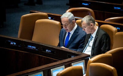 Prime Minister Benjamin Netanyahu, left, and Justice Minister Yariv Levin, right, on the Knesset floor, June 7, 2023. (Oren Ben Hakoon/Flash90)